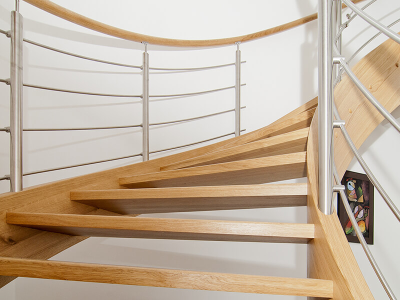 Curved wooden staircase with stainless steel elements